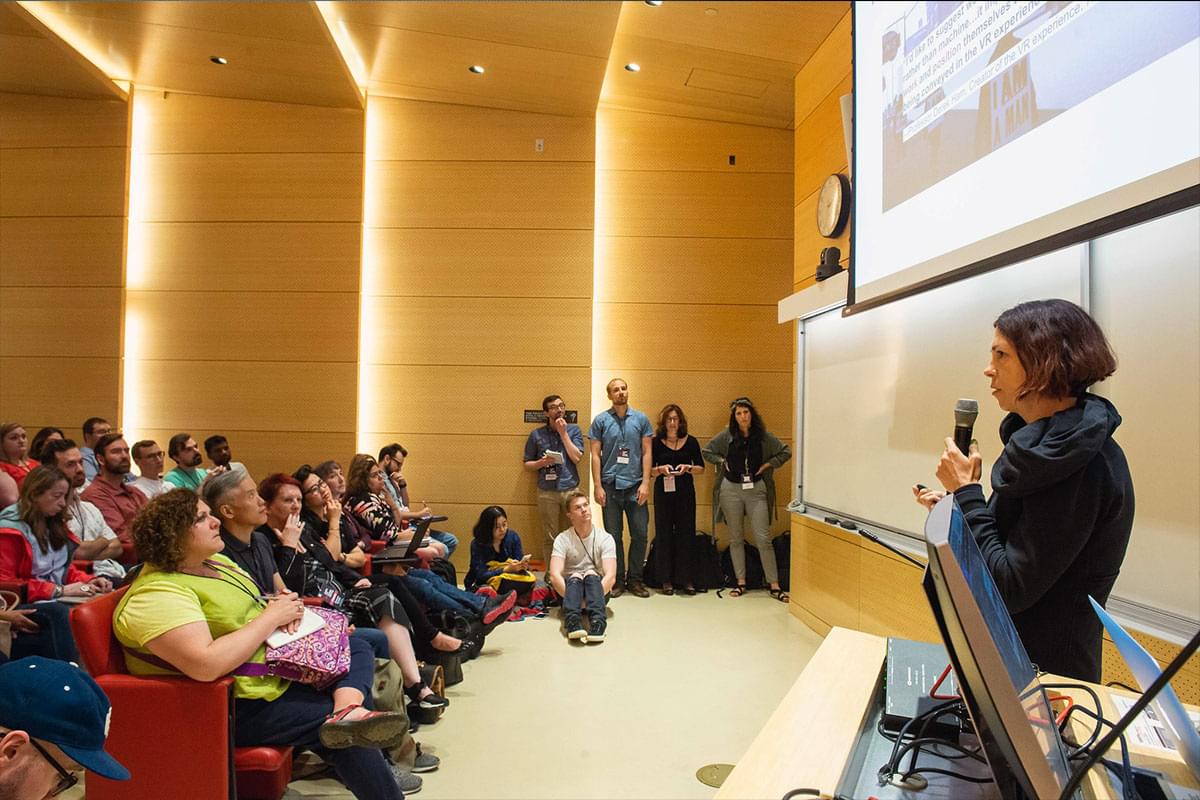 Illya Szilak delivers a talk at the 2019 Games for Change conference, pictured standing in front of an audience.